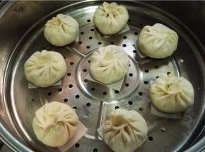 包子下面垫上油纸（屉布）。冬天温度低可以先将蒸锅水加热，然后关火，将包子放入发酵。