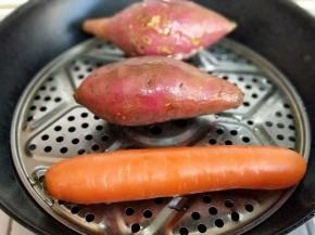 将红薯个胡萝卜洗干净，隔水蒸熟。