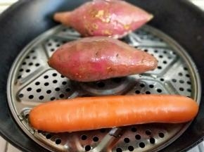 将红薯个胡萝卜洗干净，隔水蒸熟。