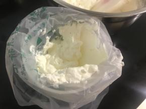 取一大勺淡奶油拌上绿色色素，等下在蛋糕底部挤上一圈绿圆珠做装饰，剩下的换个裱花嘴，挤在顶上做小草装饰