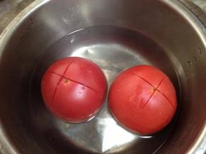 番茄顶部切十字花刀，泡入开水中一分钟剥去外皮