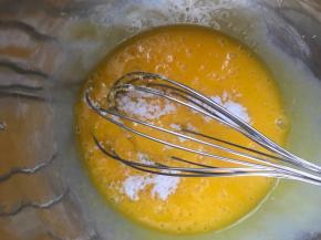 把15克糖，玉米油、牛奶加入蛋黄里，用蛋抽搅拌均匀