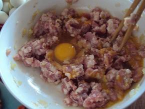 肉馅打入鸡蛋，搅散，将辅料全部放入