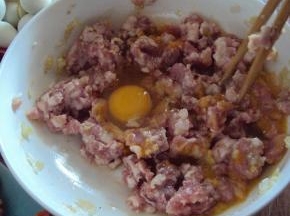 肉馅打入鸡蛋，搅散，将辅料全部放入