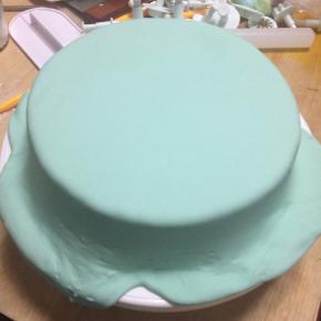 将翻糖膏轻移盖在已涂抹奶油的蛋糕坯上