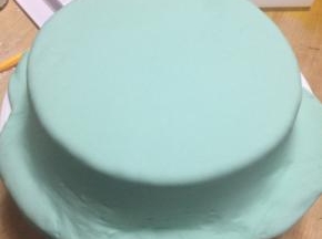 将翻糖膏轻移盖在已涂抹奶油的蛋糕坯上
