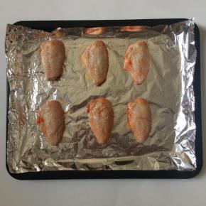 将腌制好的鸡翅放在铺了锡纸的烤盘上