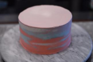 剩余的淡奶油平均分成两份，一份加入红色，一份加入蓝色，装入裱花袋，随意挤在蛋糕上，借助抹刀抹平