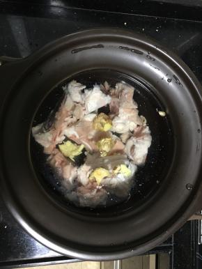 把洗净的骨头放入炖锅，加入两块拍破的姜。注入适当的清水