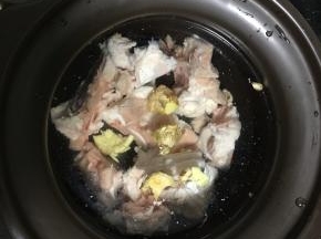 把洗净的骨头放入炖锅，加入两块拍破的姜。注入适当的清水