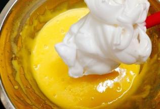 取打好的蛋白霜的一半放入蛋黄糊中