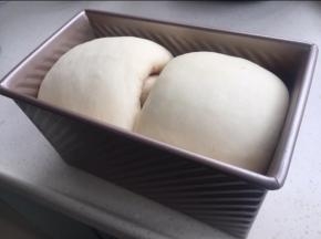 放入烤箱发酵到最高处与模具壁齐平。在面团上涂稀释的蛋液