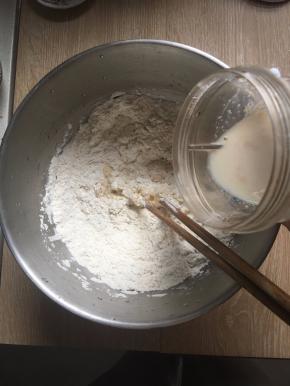 面粉倒入厨师机里，然后加入香草精、鸡蛋、盐和剩余的糖一起混合，倒入酵母牛奶液搅拌成团。（黄油不加）