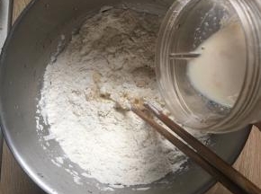 面粉倒入厨师机里，然后加入香草精、鸡蛋、盐和剩余的糖一起混合，倒入酵母牛奶液搅拌成团。（黄油不加）