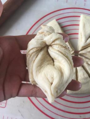 将三角的头部拉起向内弯曲穿过割口处并拉直.将尾部两边捏合在一起即可。