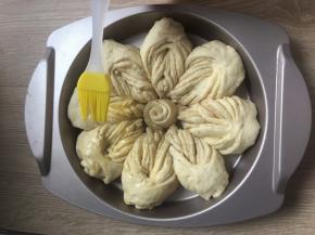 把小花蕊摆放到面包坯的中间。 盖上保鲜膜二次发酵15至20分钟。