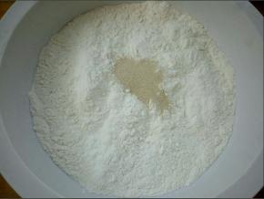 盆里放面粉，酵母，白糖，用温水边倒水边搅拌成面絮状