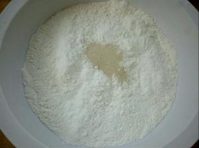 盆里放面粉，酵母，白糖，用温水边倒水边搅拌成面絮状