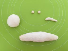 其中没有分割开的面团取一点搓成两个小三角作为猫咪的耳朵，取一点搓成长条作尾巴，另外剩下的搓成长条，两头要比中间尖，做猫的身体