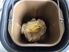 中途和面到18分钟时，按暂停键，加入软化的黄油，启动继续和面