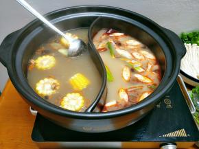 水开后清汤那边加入玉米、红枣，这样汤底更香甜，辣汤这边加入姜片和大葱