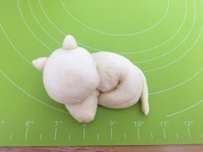 把长条面团卷起来，按上猫的脑袋、耳朵、尾巴
