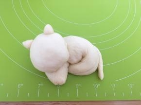把长条面团卷起来，按上猫的脑袋、耳朵、尾巴