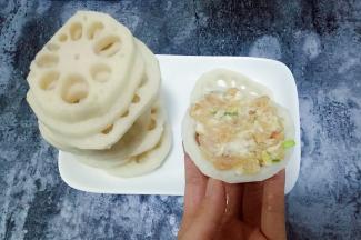 取一个藕片，在藕片上放适量肉馅