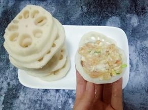 取一个藕片，在藕片上放适量肉馅