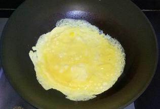锅中倒油烧热，倒入打散的鸡蛋液，摊成蛋饼