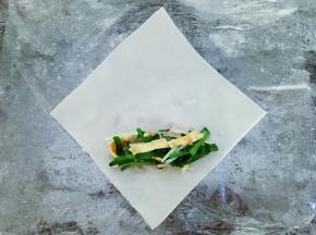 准备好春卷皮，将馅放在春卷皮上