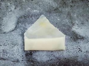 两边往中间折起来，继续卷，在三角上抹鸡蛋液