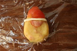 圣女果皮做了个帽子，鹌鹑蛋的蛋白做帽子边。剪半片香肠做大鼻子。