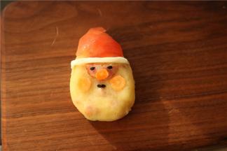 摆上黑芝麻和胡萝卜片，做出圣诞老人的五官来。建议用工具来做，会更形象逼真