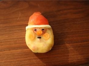 摆上黑芝麻和胡萝卜片，做出圣诞老人的五官来。建议用工具来做，会更形象逼真