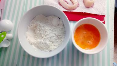 准备好一碗中粉，中粉中加入盐巴3g+胡椒粉2-3g,再准备打好的鸡蛋。先把吸干水份的鱿鱼放中粉中搅拌均匀再放入鸡蛋中上浆。