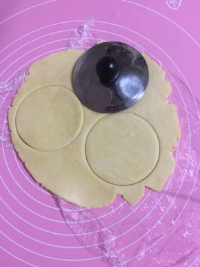 用茶壶盖按压成圆片！(如果有大一点的饼干模具来按压就更好啦！一定不要太小，否则后面不好包馅；我家的饼干模具都太小了，只好用茶壶盖来按压，也很方便哦！)