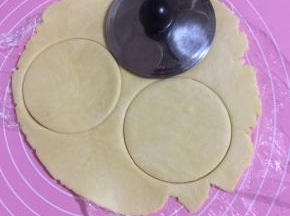 用茶壶盖按压成圆片！(如果有大一点的饼干模具来按压就更好啦！一定不要太小，否则后面不好包馅；我家的饼干模具都太小了，只好用茶壶盖来按压，也很方便哦！)