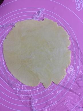 取一块松弛好的面团擀成3、4毫米的面片！（保鲜膜不用取直接擀，如果取了就撒少许低筋面粉防粘。)