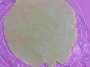 取一块松弛好的面团擀成3、4毫米的面片！（保鲜膜不用取直接擀，如果取了就撒少许低筋面粉防粘。)