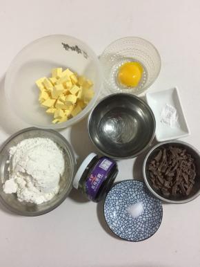 准备好所需食材:

低筋面粉180克
泡打粉1克
黄油100克(黄油无需融化，切成小块即可！)
盐1克
凉水40克
蓝莓酱适量
黑巧克力少许(黑巧克力切成小块儿！)
蛋黄1个
蛋黄用凉水1勺