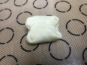 取一个面团，两端对折，压扁