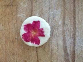 将剂子按压成饼，取玫瑰花瓣贴在糯米饼上面即可