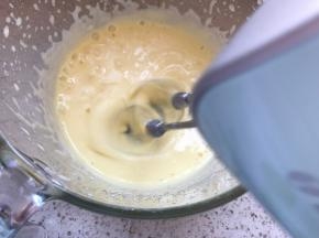 边打发蛋黄，边缓慢分次加入蛋黄糊，这一步是给蛋黄杀菌，打发至温热
