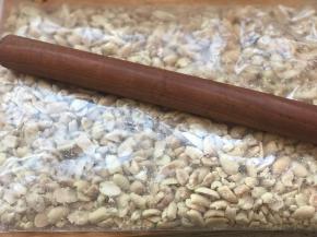 花生凉后，取520克，放入食品袋内，用擀面杖便宜敲碎一点