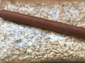 花生凉后，取520克，放入食品袋内，用擀面杖便宜敲碎一点