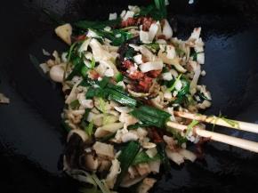 用筷子扒拉豆丝，时不时用铲子铲下，倒入瘦肉丝，炒匀