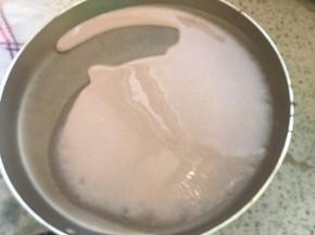 拿到旁边，离开火源，倒入适量面糊，转动锅子，均匀布满面糊，如果你的锅倒入面糊后，转不动，立刻就凝固了（如图），说明，你的锅温度太高，应该准备一块湿抹布铺在桌子上，把锅放湿抹布上降温后，再倒面糊