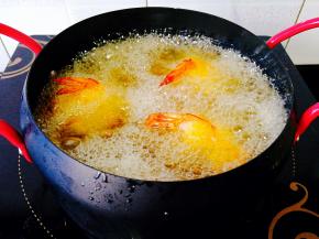 锅中倒入油，烧至6成热，放入裹好的土豆虾球，中间要把虾球翻一翻，炸至金黄色即可捞出，控干油份摆盘，挤上些番茄酱蘸着吃