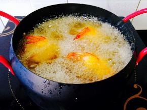 锅中倒入油，烧至6成热，放入裹好的土豆虾球，中间要把虾球翻一翻，炸至金黄色即可捞出，控干油份摆盘，挤上些番茄酱蘸着吃